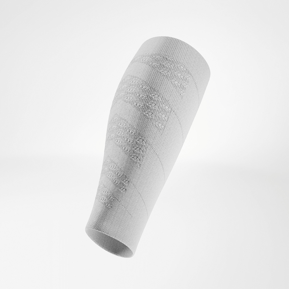 Sleeve a compressione bianca in vista angolata, la forma sagomata si adatta perfettamente al polpaccio, per sostegno e movimenti dinamici.