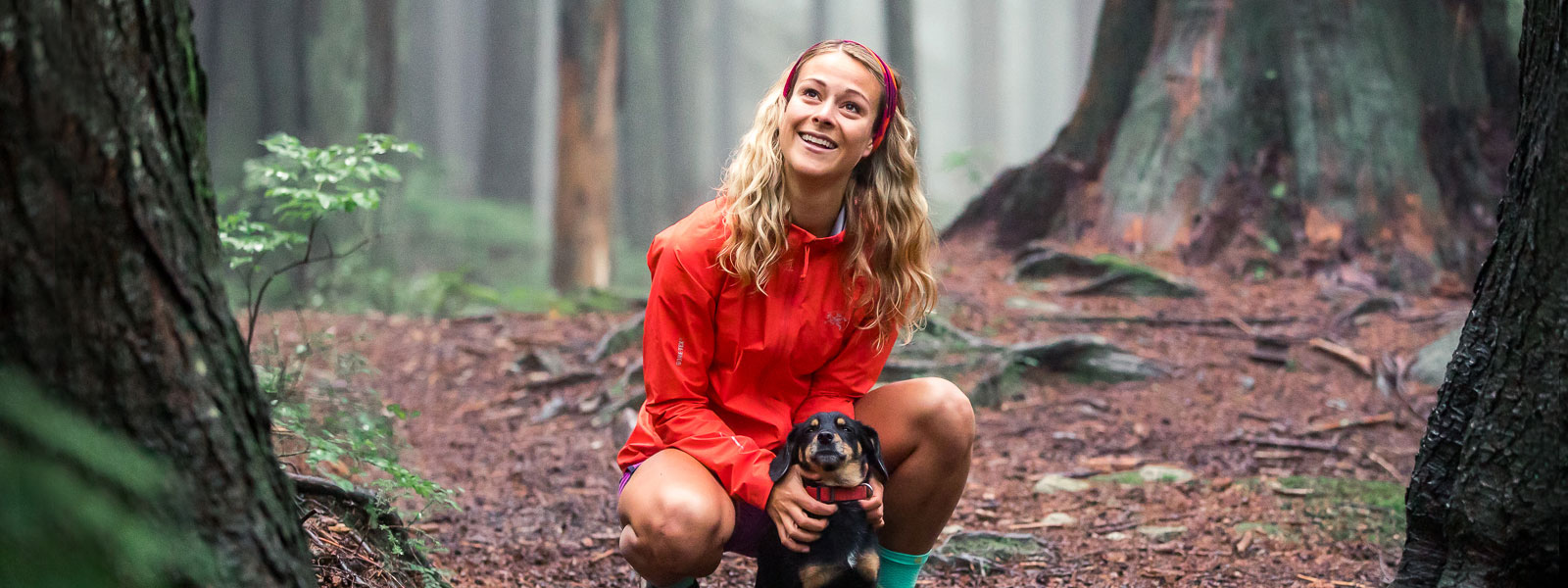 Waldidyll con cane: Hailey van Dyk durante una piccola pausa La donna con una giacca rossa e una fascia tiene il suo cagnolino su un sentiero forestale e sorride