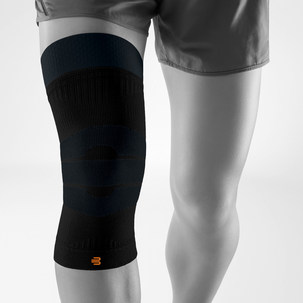 Ginocchiera nera per attività outdoor, indossata sulla gamba, offre compressione mirata e stabilità durante sport e movimento all’aperto.
