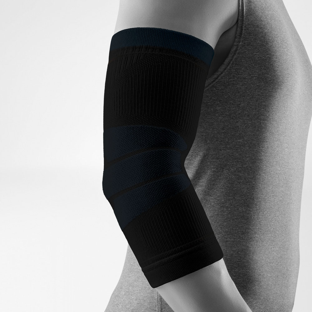 Immagine in studio di un Outdoor Compression Elbow Support nero indossato su un braccio leggermente piegato. La fascia compressiva avvolge il gomito in modo uniforme, evidenziando diverse zone di lavorazione su sfondo neutro.