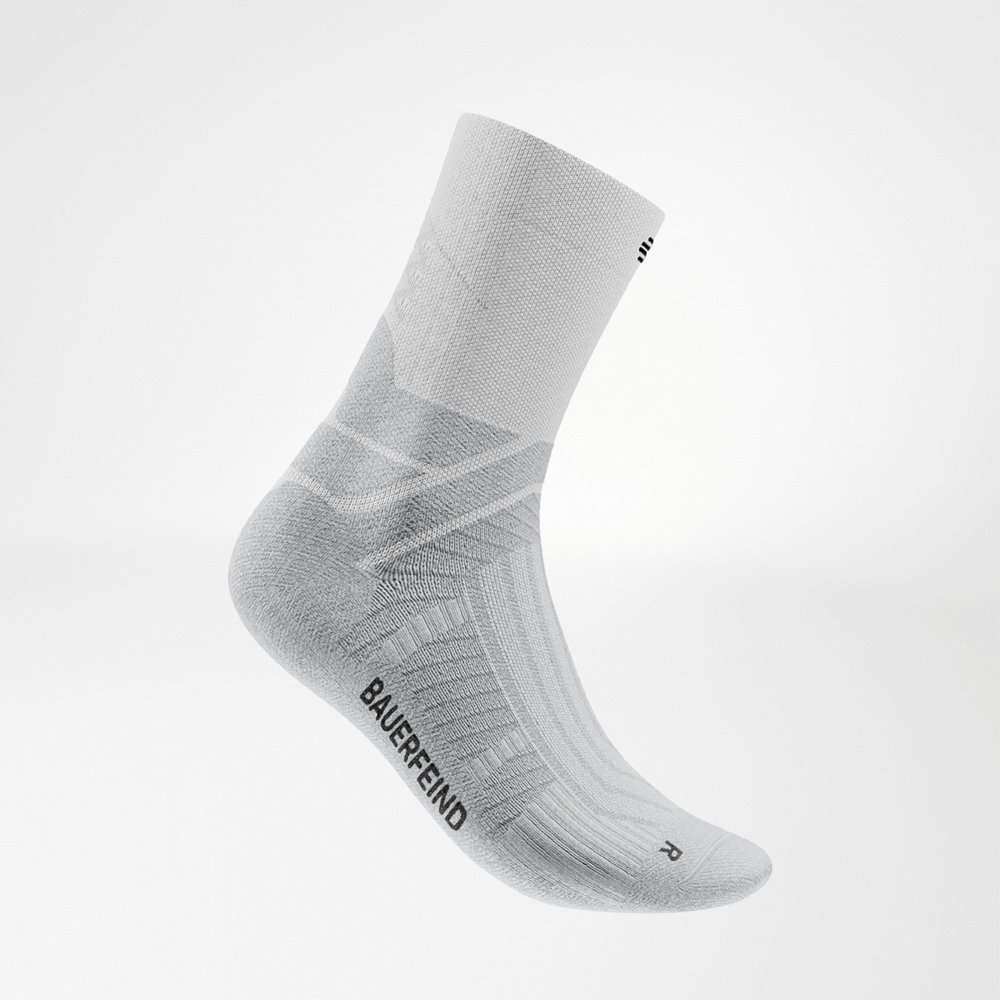 Leggero e fresco – la tua corsa in bianco. Vista laterale dettagliata di una calza bianca Bauerfeind Run Performance Midcut con strutture a zone visibili e logo nero.