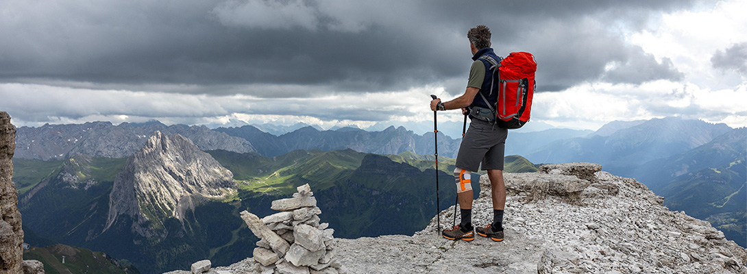 Alpinista sulla cima di una montagna Alpinista sulla vetta di una montagna che indossa una ginocchiera da esterno