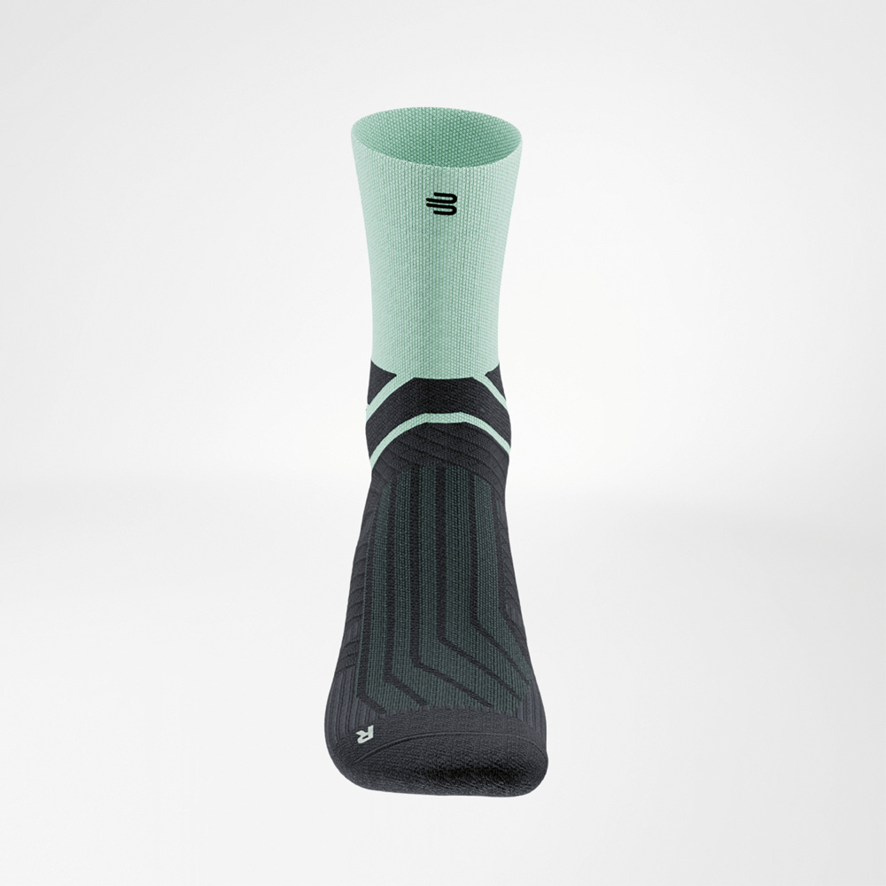 Vista frontale di una calza Run Performance Midcut verde e nera con design a contrasto e carattere sportivo.