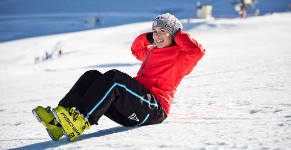 Ski Runner in una giacca rossa fa un seduta sulla neve