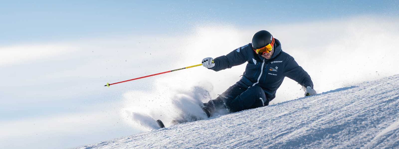 Nato a Ski: condividi la nostra passione per la neve e le belle discese? Gli sciatori in un abito scuro in una pendenza estrema sulla partenza