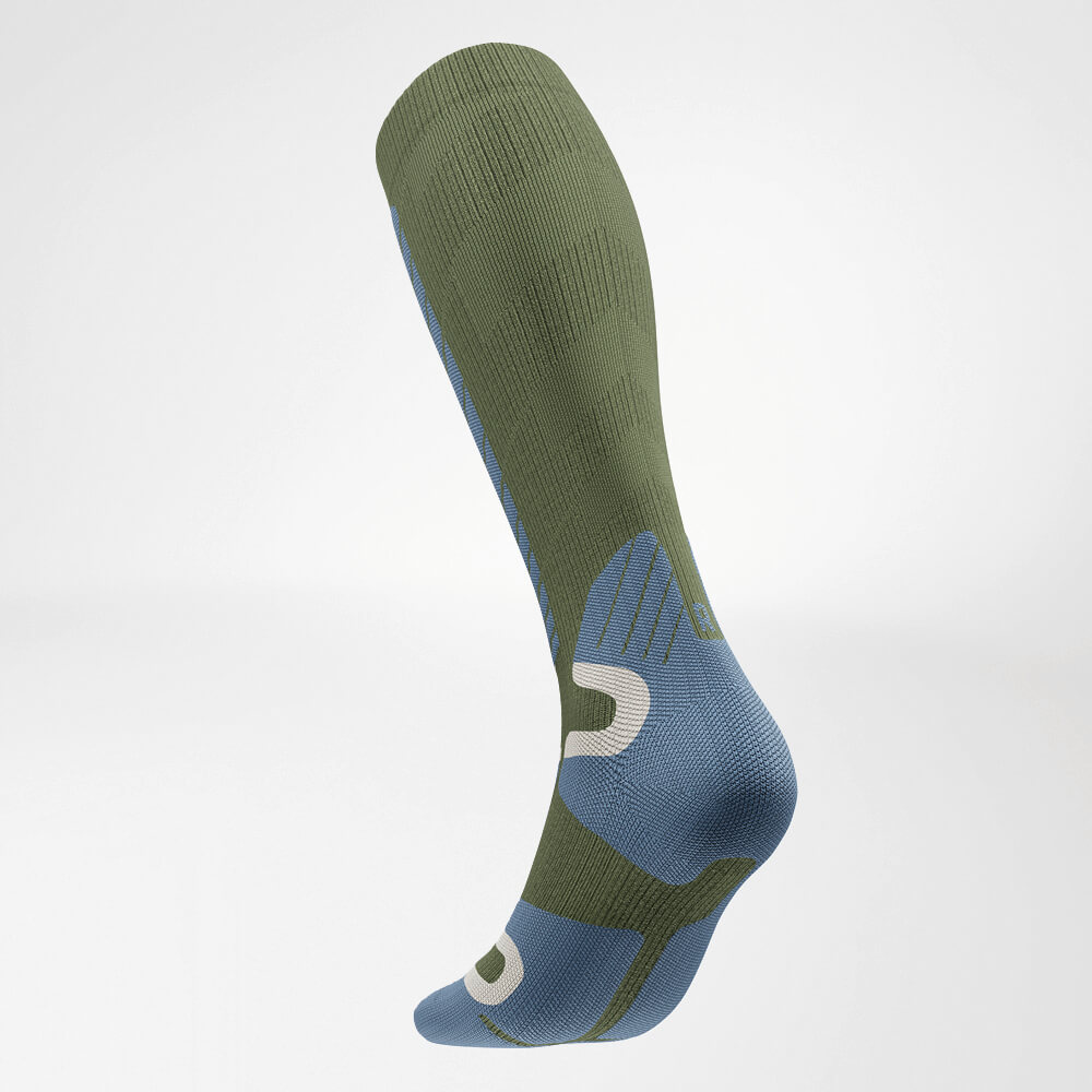 Vista posteriore inclinata di un calzino a compressione da sci verde fino al ginocchio, con design a maglia strutturato per supporto e comfort ottimali durante lo sci.
