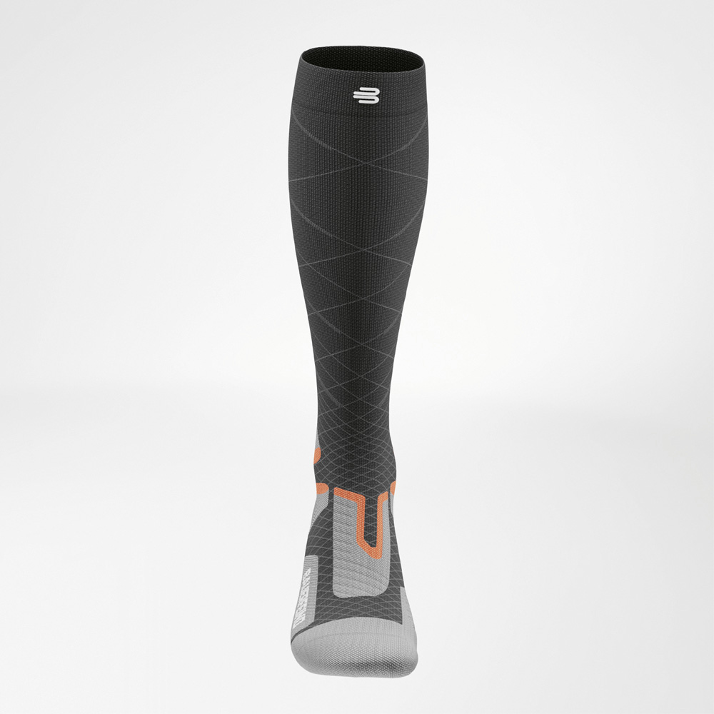 Controllo assoluto alla massima velocità Vista frontale della calza Ski Performance di Bauerfeind Sports. Le linee sottili indicano la compressione graduale, mentre gli accenti arancioni segnalano aree di supporto.