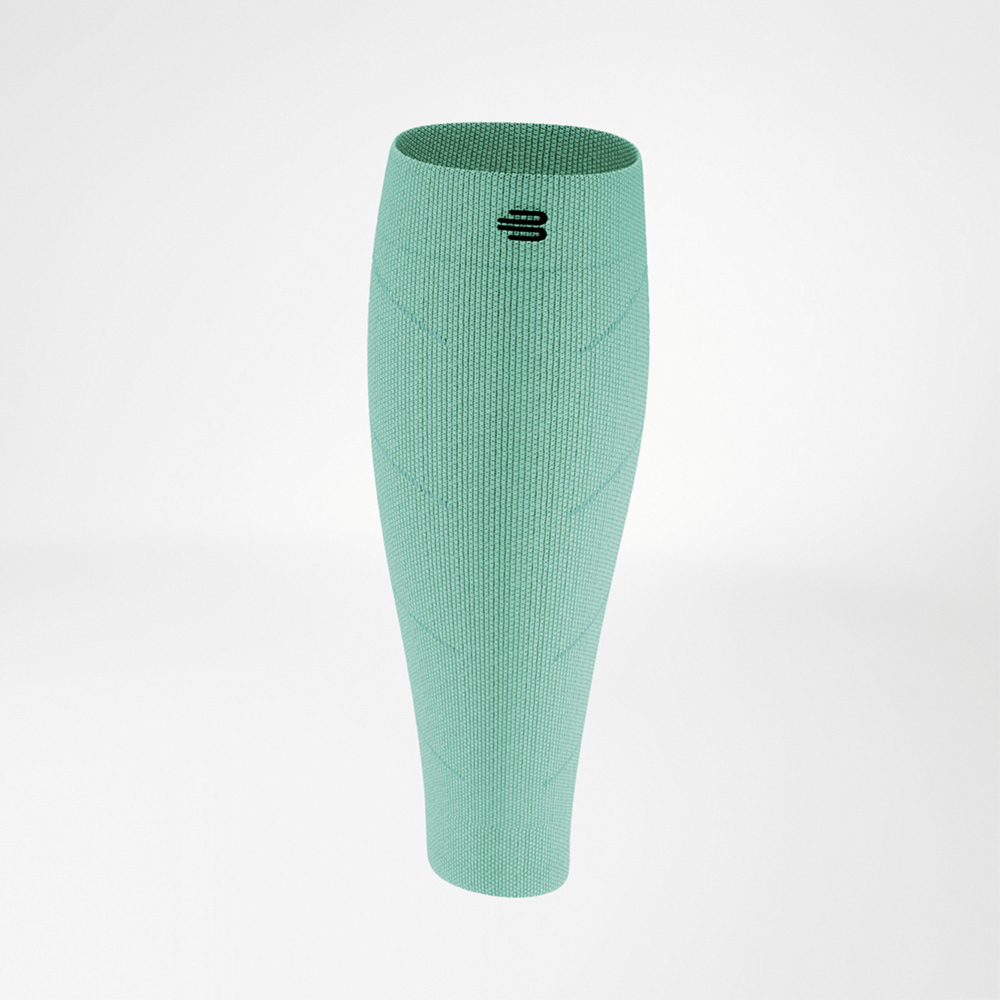 Sleeve a compressione in verde intenso, mostrata frontalmente. Il materiale elastico aderisce al polpaccio, con il logo nero posizionato sopra il centro. La struttura a maglia presenta linee diagonali per un look dinamico.