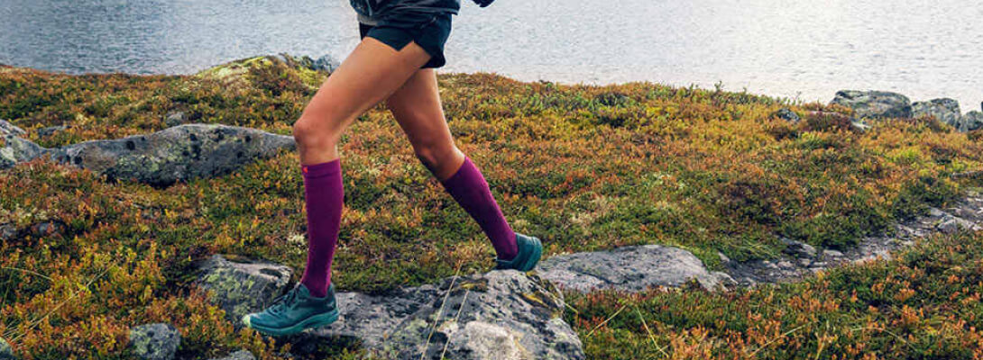 Calzini a compressione Sport Berry UTreatet durante la corsa Corridore con calzini a compressione leggeri rosa per correre su un sentiero