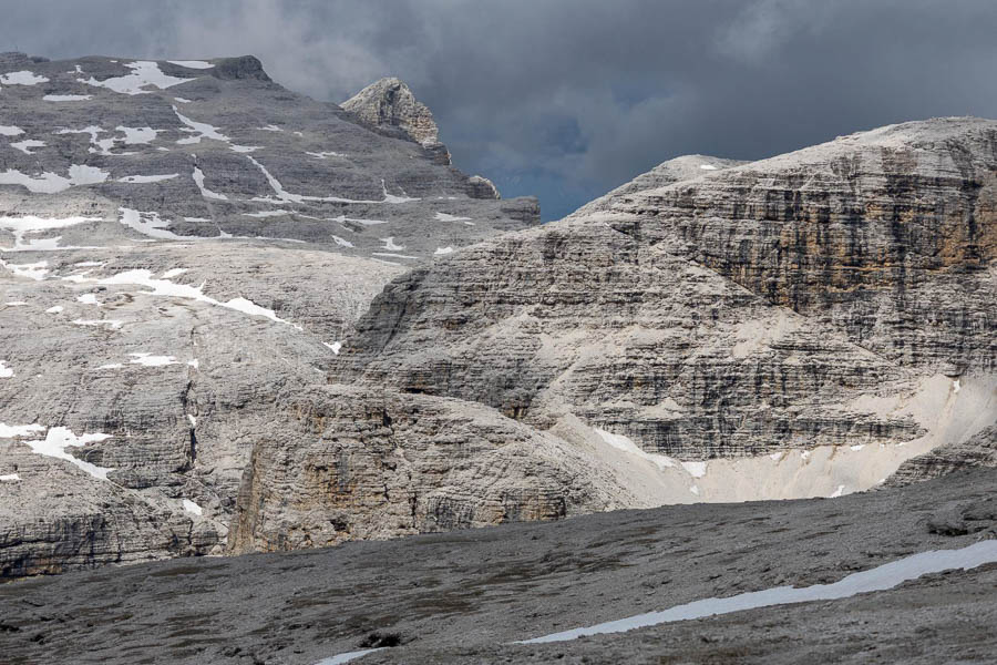 Paesaggio roccioso nelle Dolomiti Un paesaggio roccioso nelle Dolomiti con chiazze di neve sparse e un cielo nuvoloso.