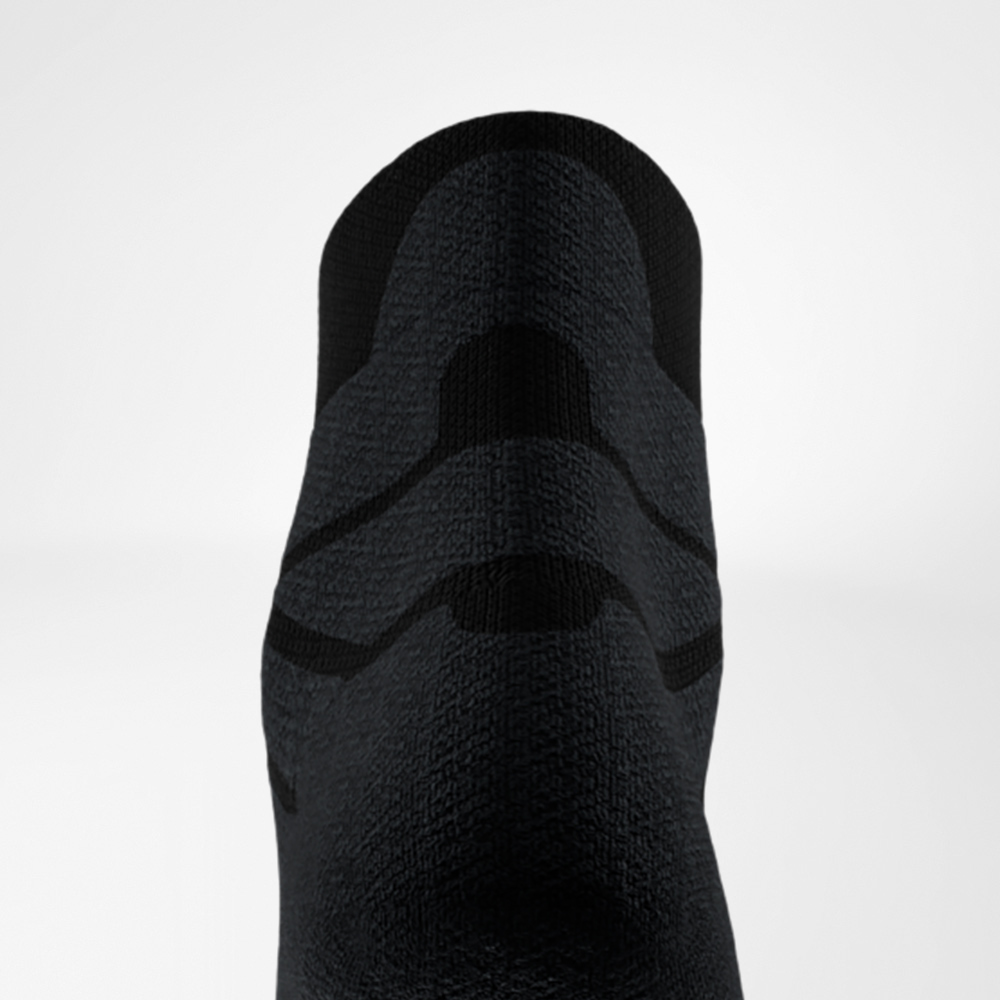 Primo piano del retro di una calza sportiva nera con imbottitura strutturata visibile nella zona del tendine d’Achille, per maggiore protezione e comfort nella corsa.