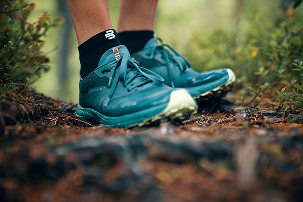 Chiudi le scarpe da escursioni superiori su un pavimento della foresta