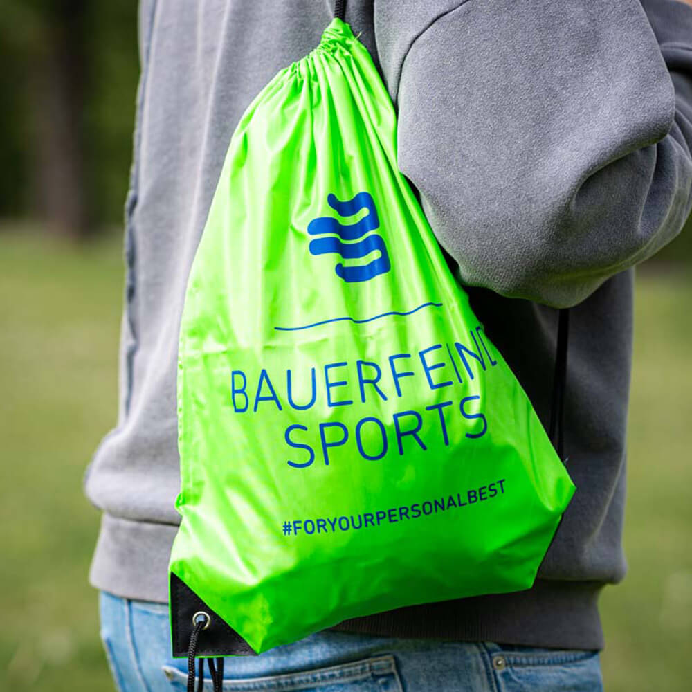 Il tuo compagno: Lo zaino Bauerfeind Sports per ogni occasione Una persona porta uno zaino verde Bauerfeind Sports sulla spalla all'aperto.