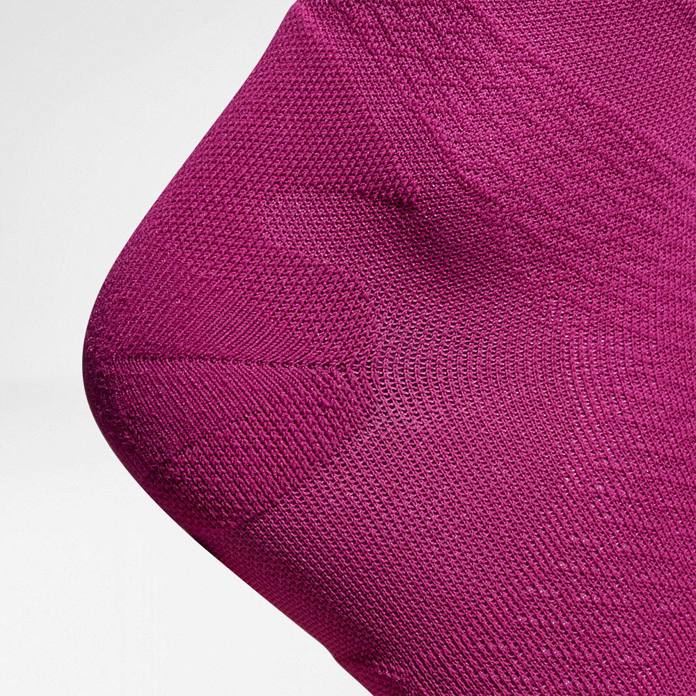Vista dettagliata sulla zona di protezione del tallone dei calzini a compressione a trasmissione ariosi color rosa e correre