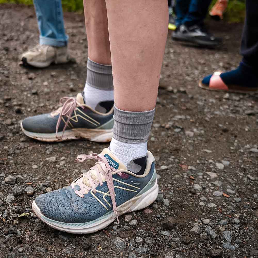 Le calze Trail Run Mid Cut per il Rennsteiglauf Le gambe e le scarpe di una donna che indossa le calze Bauerfeind Trail Run Mid Cut