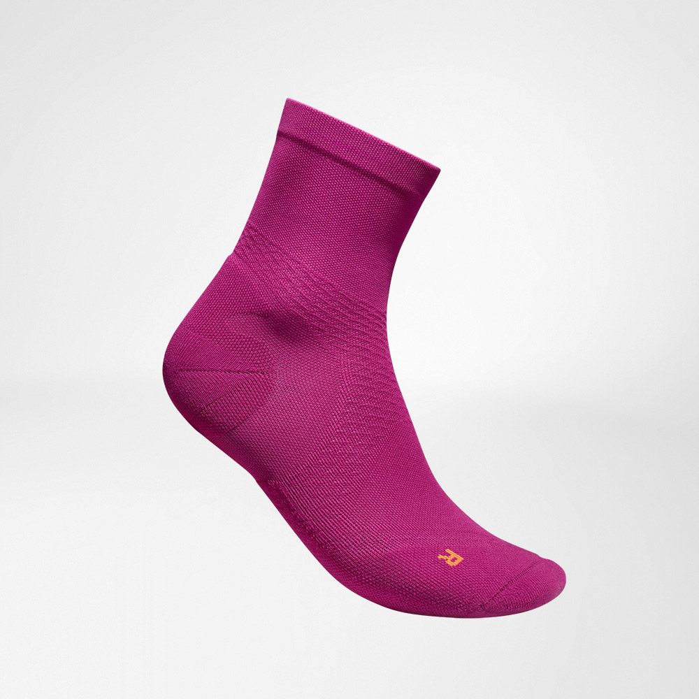 Vista laterale completa delle calze da corsa rosa a maglia ariosa di media lunghezza