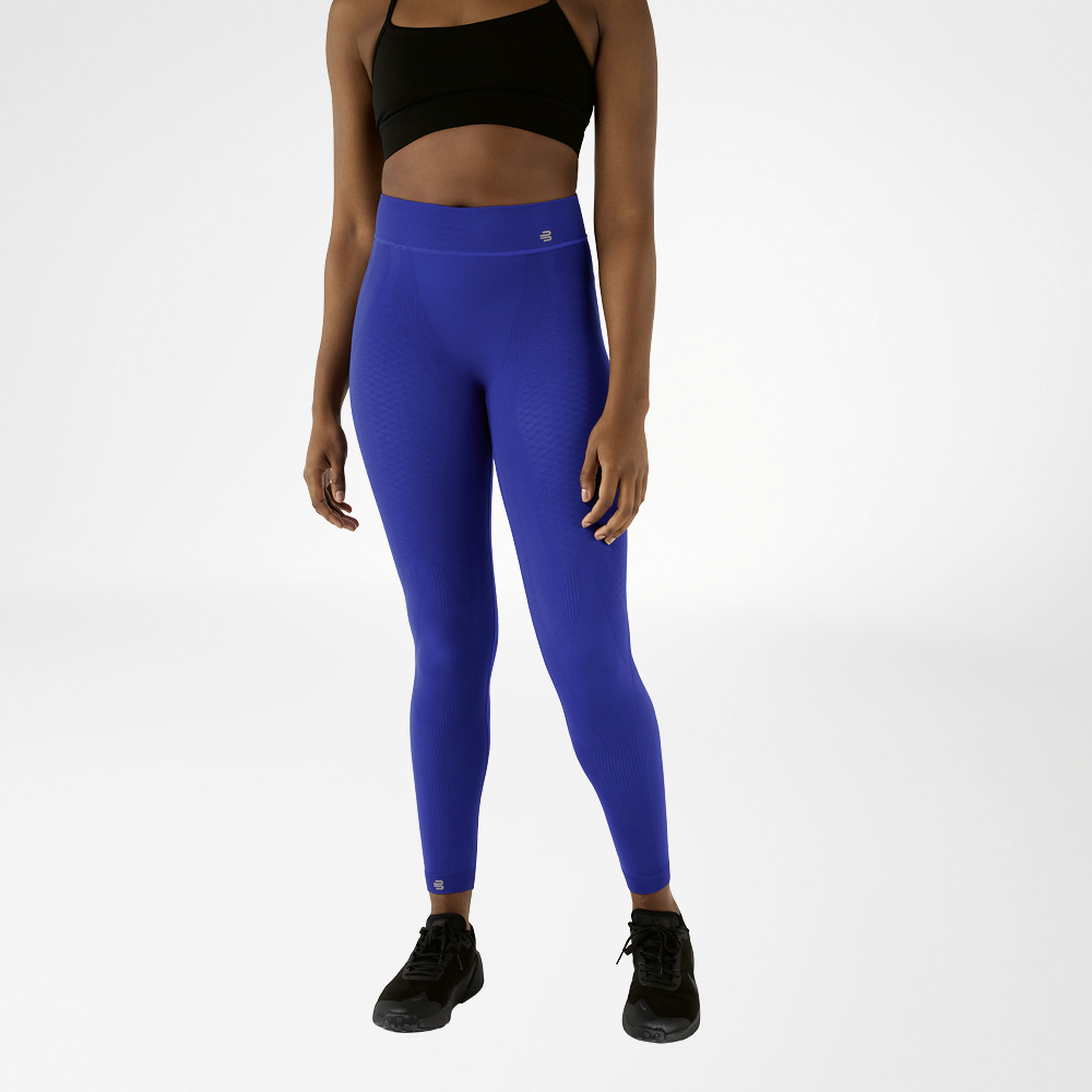Una donna con reggiseno sportivo nero e pantaloni sportivi blu navy a vita alta, lunghi fino alla caviglia