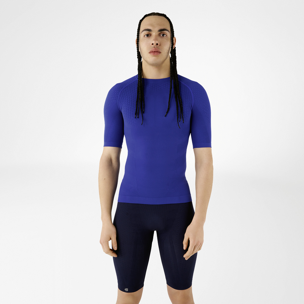 Un uomo in abbigliamento compressivo blu in piedi che guarda la fotocamera.