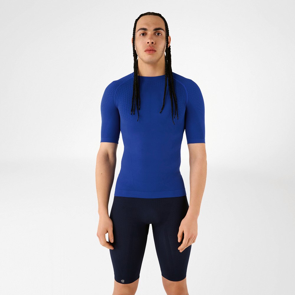 Un uomo in abbigliamento compressivo blu in piedi che guarda la fotocamera.