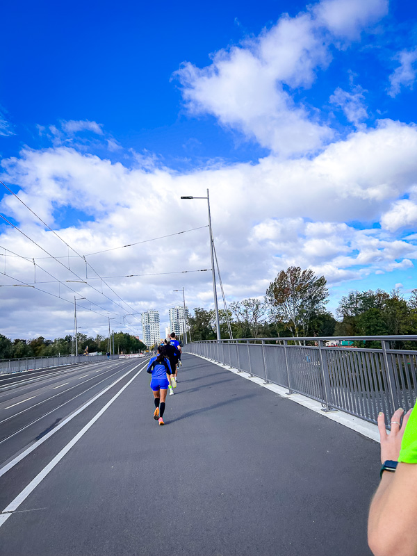 Forte vento contrario e nessun gruppo protettivo alla mezza maratona I corridori su un ponte affrontano forti venti contrari senza l'aiuto di un gruppo protettivo durante la mezza maratona.