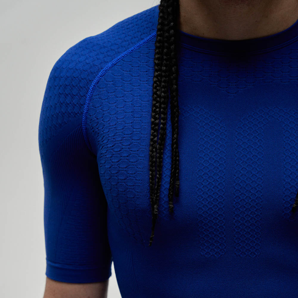 Top sportivo e compressivo blu scuro Spalla di un atleta con top sportivo blu scuro