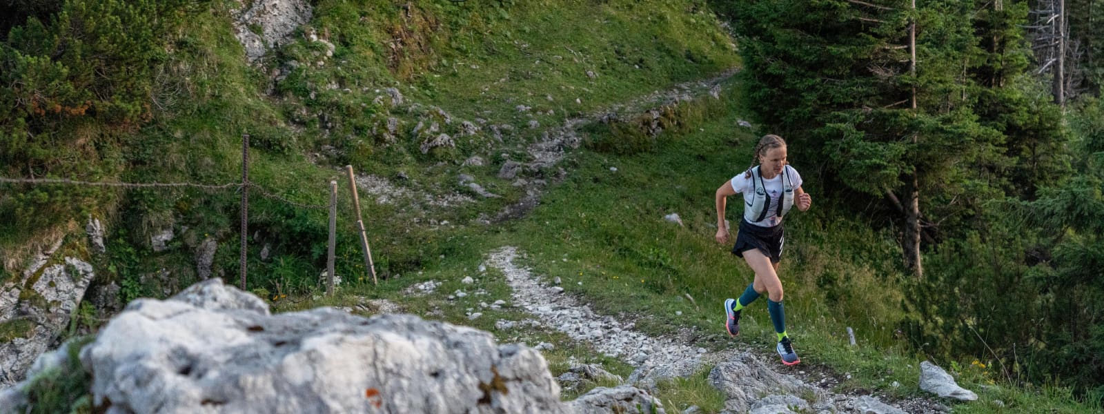 Anche fermo su terreni collini: con i calzini per pista Il corridore ha calzini da corsa e faceva jogging su un terreno pietroso e collinare nella foresta