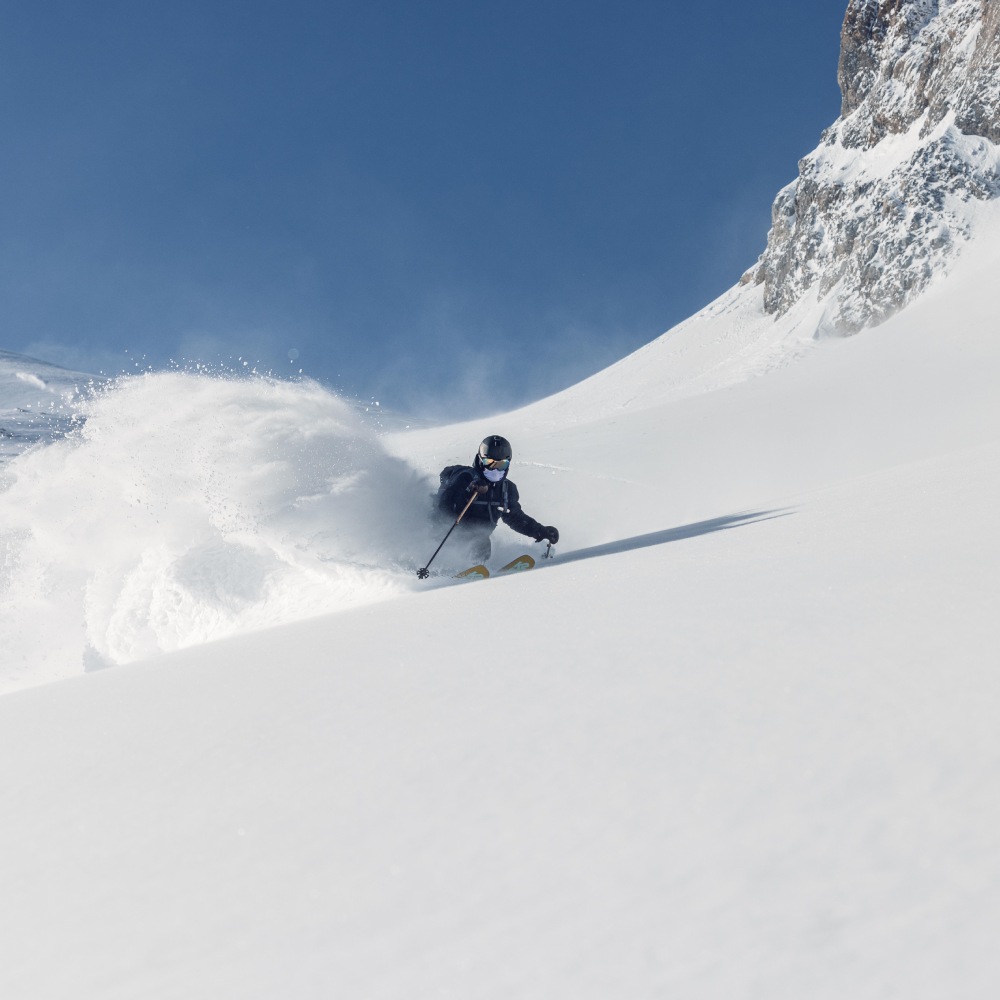 Sciatore in neve fresca con gli sci da discesa