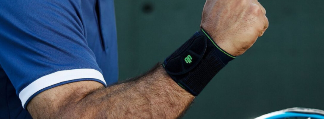 Band da polso nero in nero durante lo sport Braccio di un tennista con bendaggio da polso
