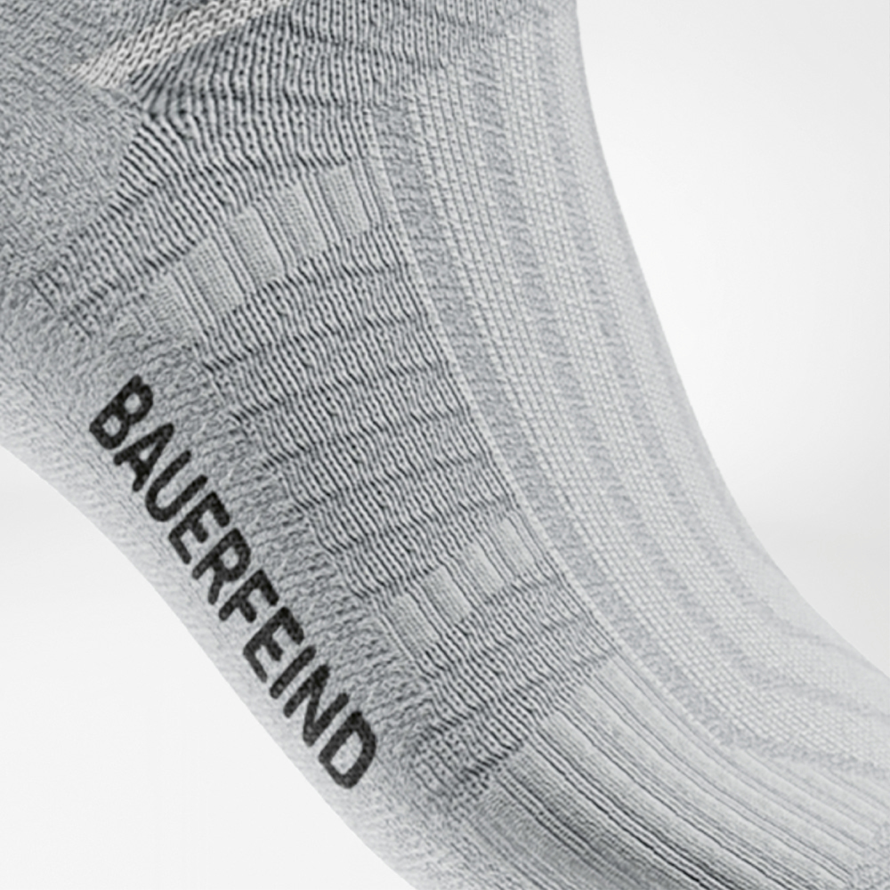 Fresco, leggero, imbattibile – corri libero in bianco! Dettaglio di una calza da running midcut bianca di Bauerfeind, con struttura a coste e zona di supporto integrata all’arco plantare. La lavorazione traspirante e senza cuciture garantisce comfort e stabilità ad ogni corsa.