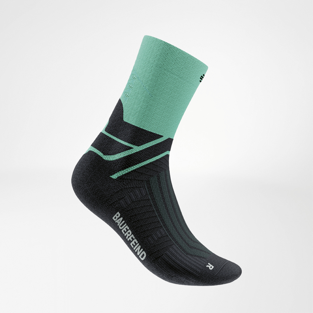 Calza da corsa nera con polsino color menta e rinforzi in tinta. Visibile il logo Bauerfeind e la Infinity Zone per un sostegno sicuro.