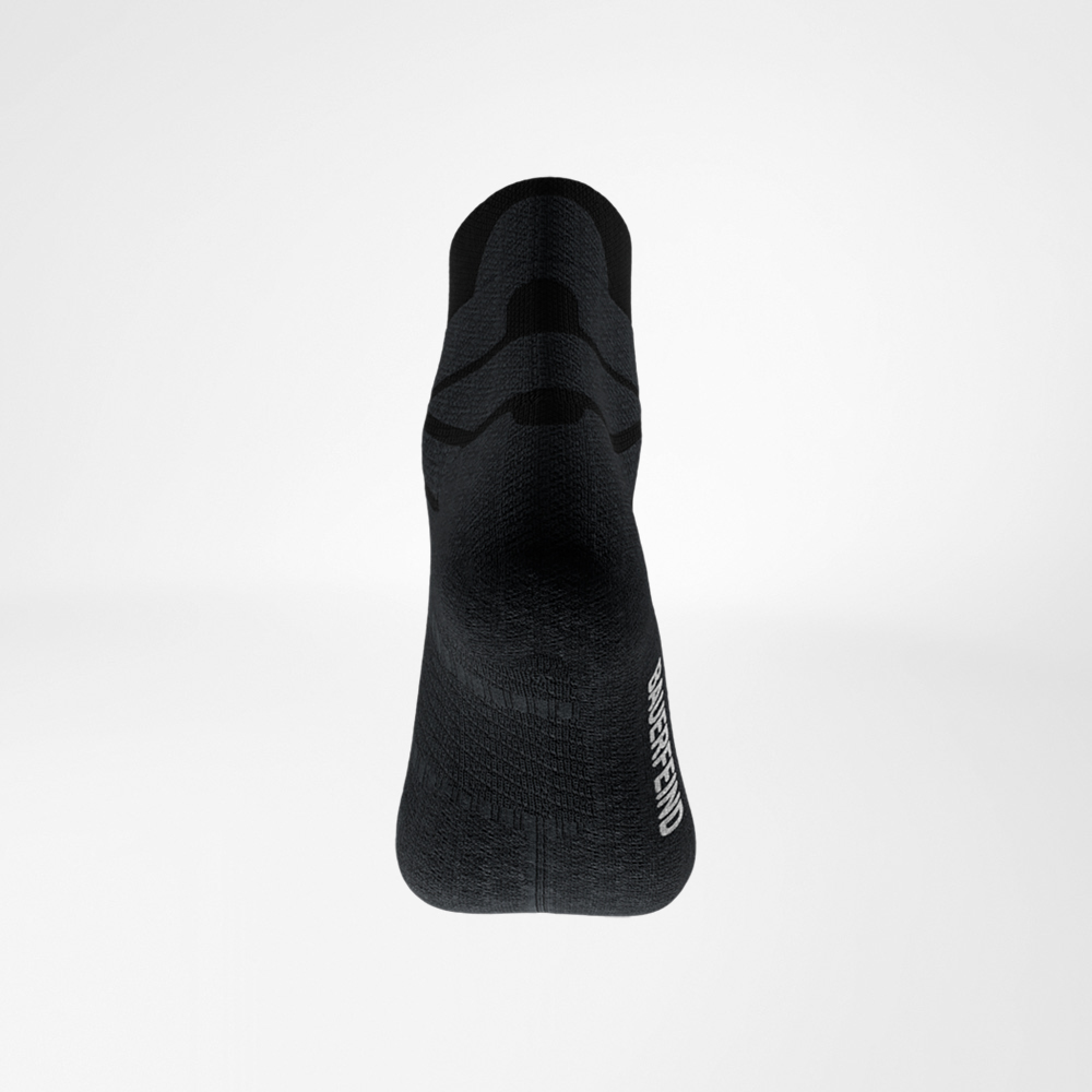 Vista posteriore della calza nera Run Performance Low Cut di Bauerfeind, tallone in primo piano, struttura a maglia fine e logo laterale visibile.