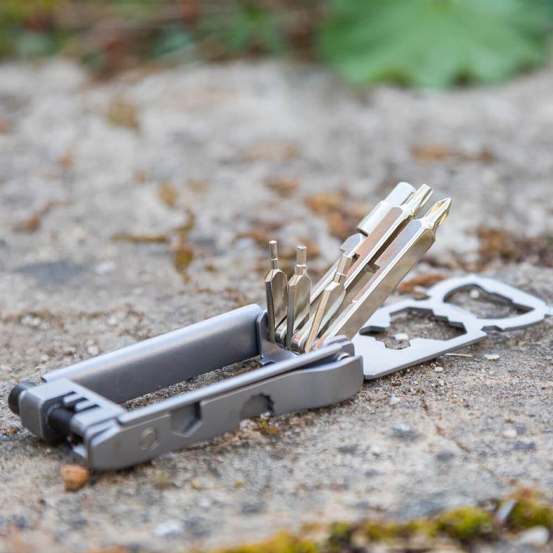 Multitool Bauerfeind Sports aperto con diverse punte e funzioni su una superficie in pietra all’aperto – perfetto per restare flessibile in movimento e mantenere la bici sempre pronta all’uso.