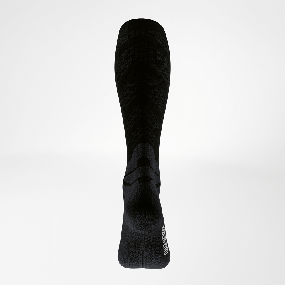 Vista posteriore di una calza da corsa nera con zone funzionali su polpaccio e tallone e strutture a compressione per un supporto muscolare mirato.