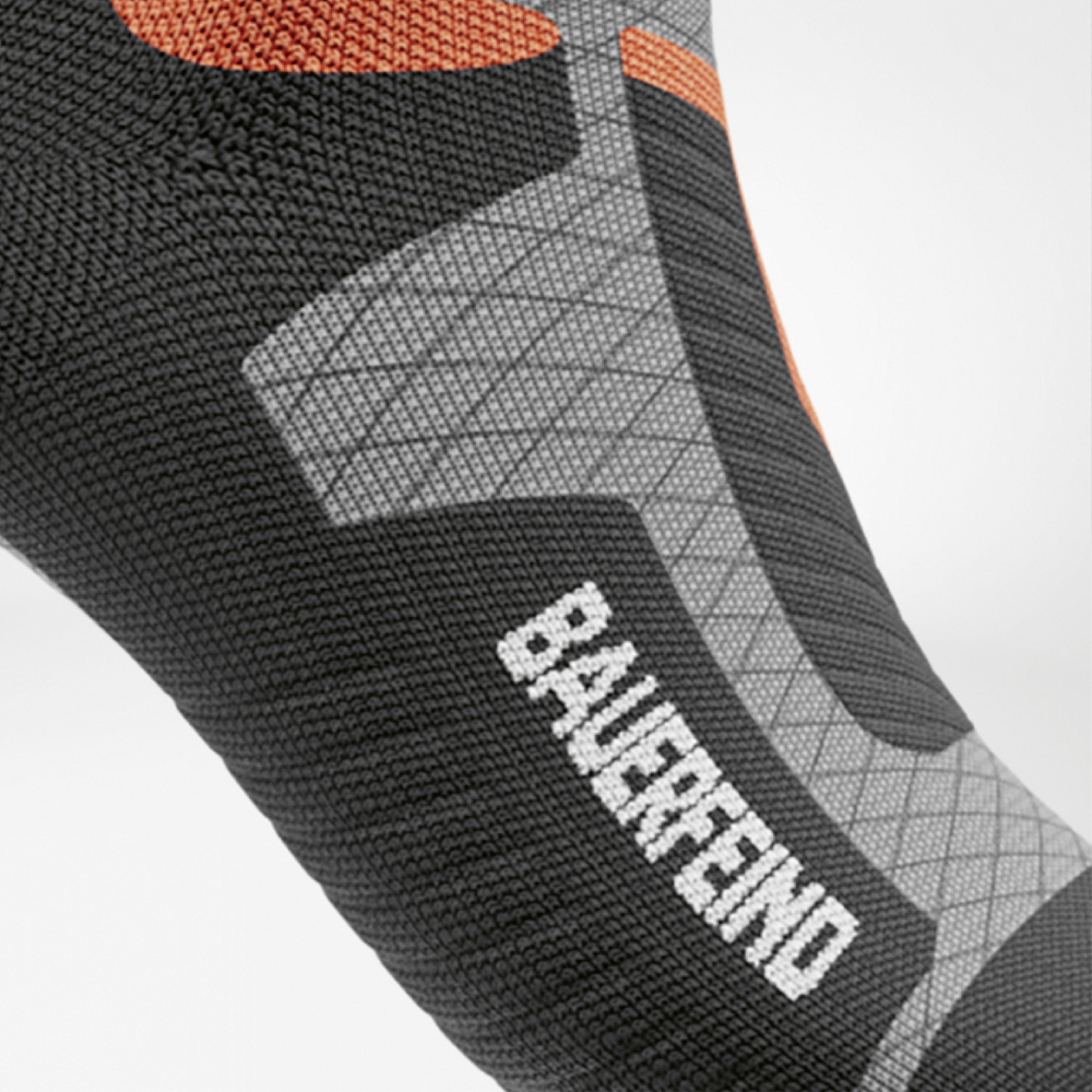 Performance visibile – con il supporto BAUERFEIND ad ogni passo Dettaglio laterale del piede della calza compressiva da sci da donna con logo BAUERFEIND e zone ergonomiche a maglia.