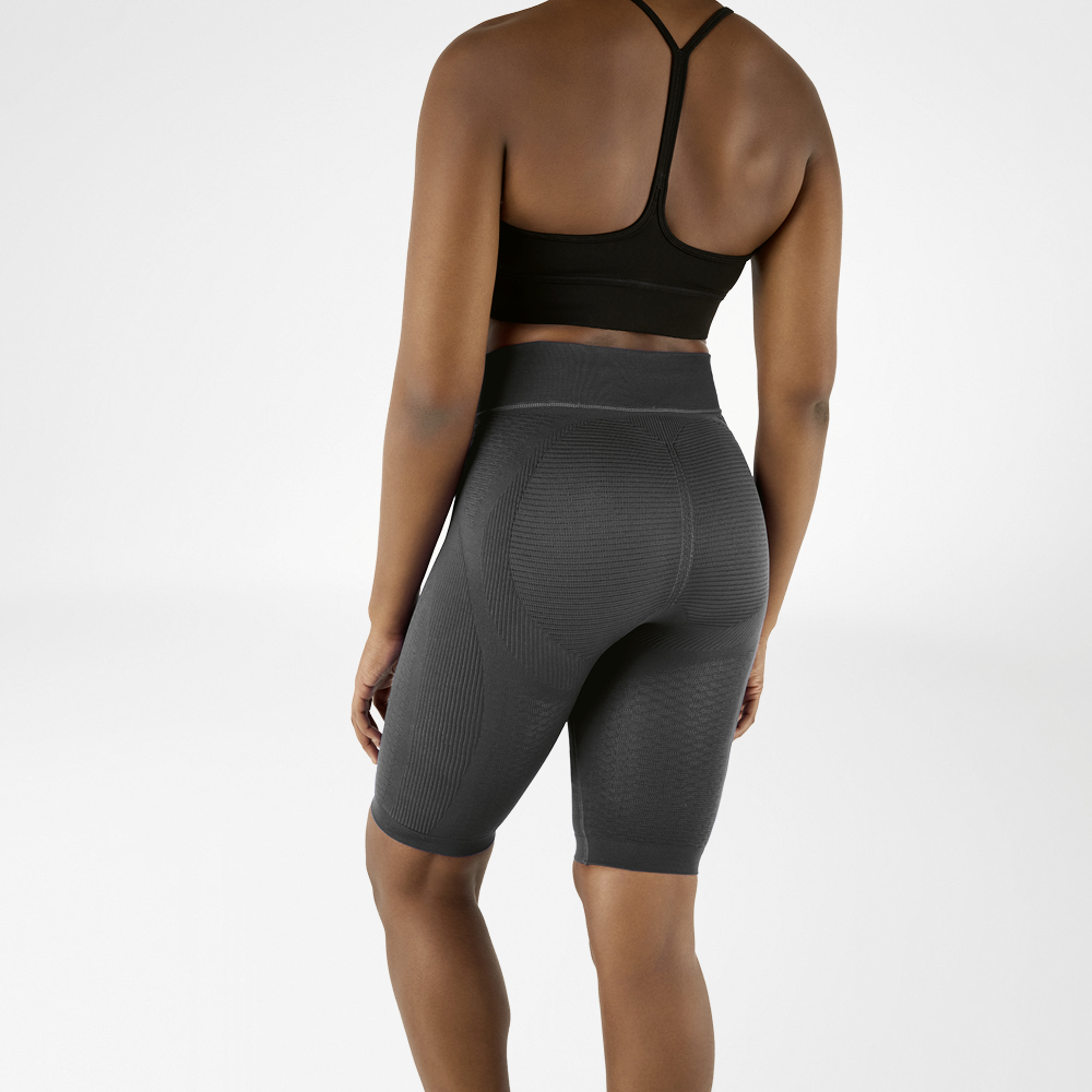  Donna fotografata da dietro con reggiseno sportivo nero e leggings a compressione color antracite al ginocchio.