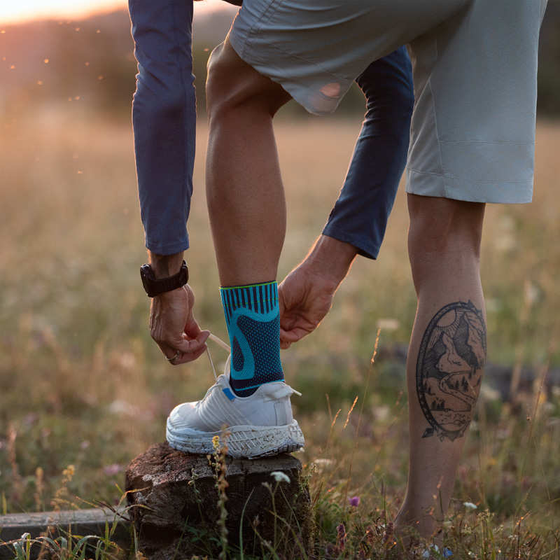 L'uomo con una benda del piede lega la scarpa da corsa con il piede su un moncone