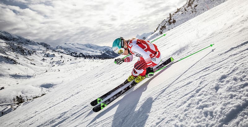 Ski Driver in una tuta da corsa rossa e bianca in un'estrema pendenza sulla partenza