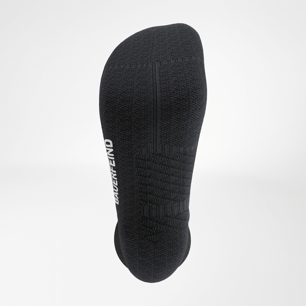 Dettaglio della pianta di una calza da corsa nera con struttura ammortizzata, cuciture ergonomiche e logo BAUERFEIND laterale.