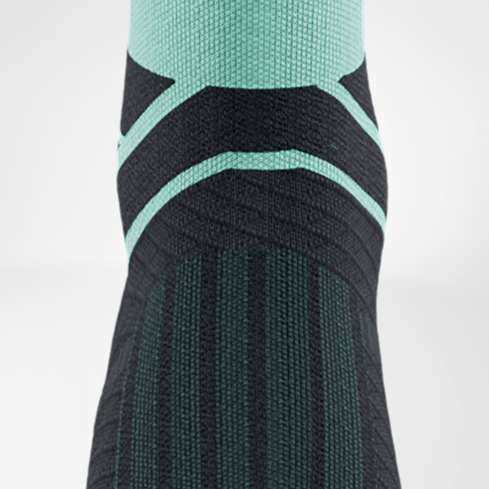 Primo piano delle Run Performance Midcut Socks in menta con motivo nero. L’immagine mostra la zona del collo del piede e la transizione verso la caviglia, con la struttura a maglia aderente che garantisce supporto e traspirabilità.