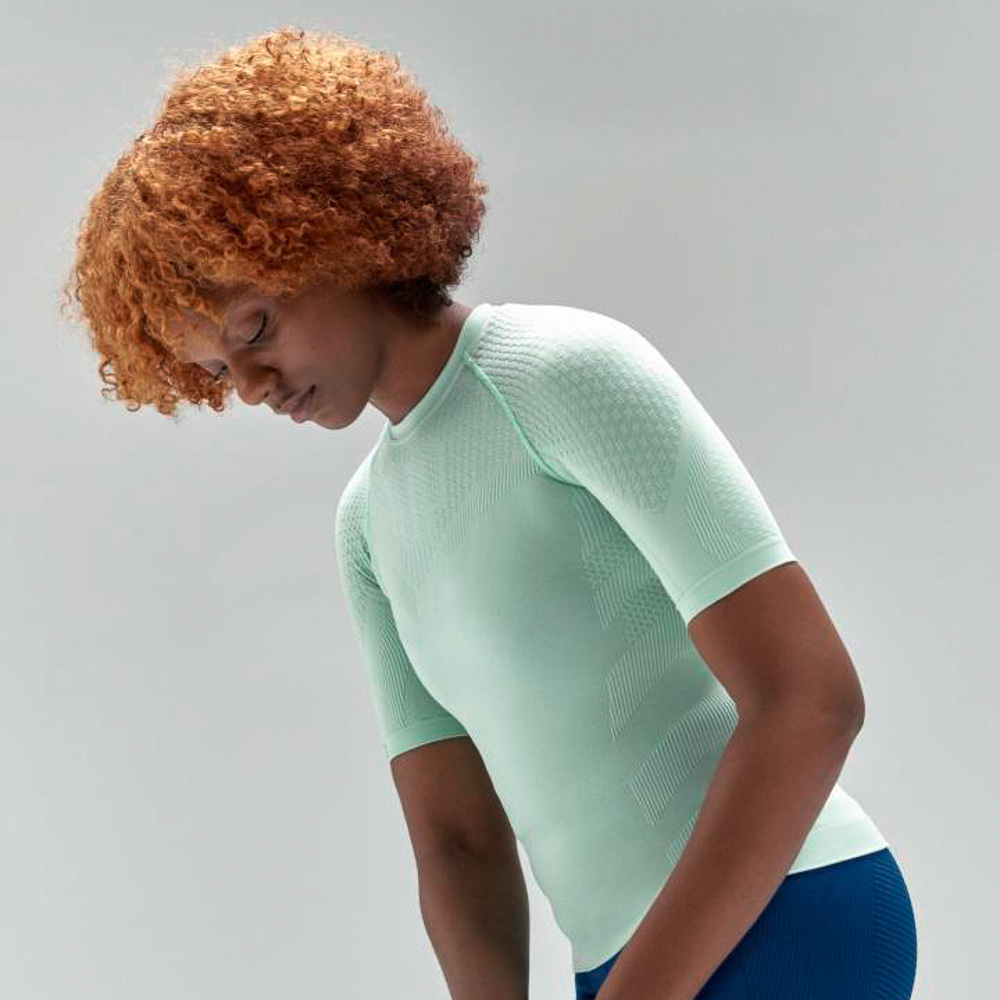 Top a compressione verde menta per donna Donna con riccioli rossi e top sportivo verde menta si allunga leggermente