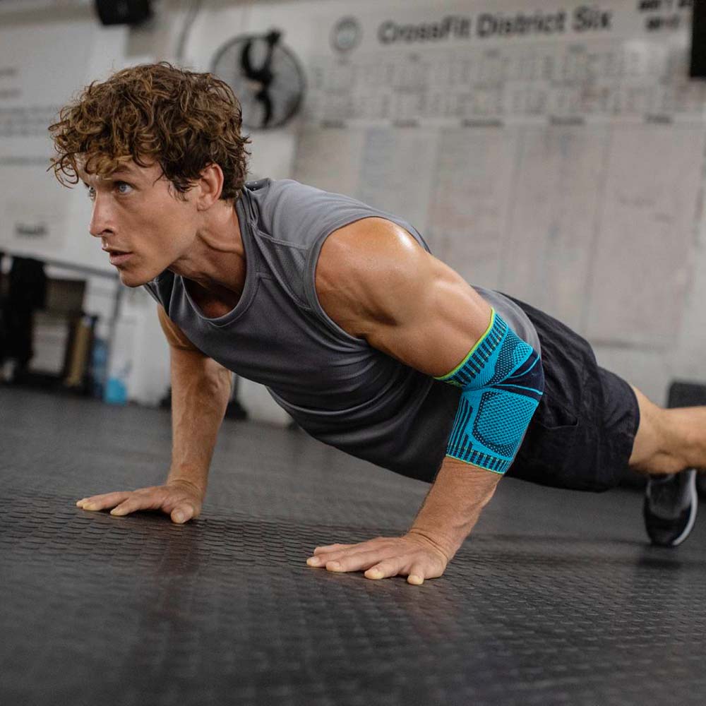 Ellenbogen Bandage at Fitness Il giovane fa push-up in palestra e indossa una fascia di gomito a Rivera