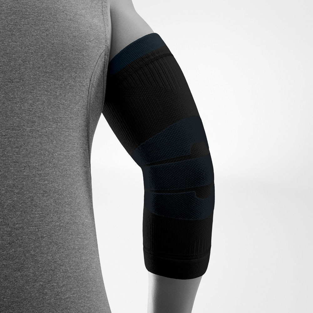 Vista laterale della Outdoor Compression Elbow Support nera indossata sul braccio. La fascia compressiva avvolge il gomito e l’avambraccio e presenta diverse zone lavorate a maglia, pensate per offrire stabilità e libertà di movimento.